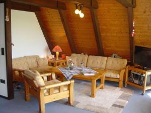 a living room with a couch and a table at Ferienhaus in Fedderwardersiel mit Terrasse und Garten in Butjadingen