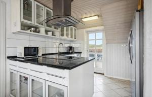eine Küche mit weißen Schränken und einer schwarzen Arbeitsplatte in der Unterkunft Pet Friendly Home In Ringkøbing in Nørre Lyngvig