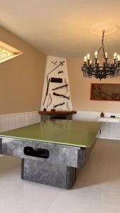a ping pong table in a room with a chandelier at Villa Dei Tigrotti in Santa Maria di Castellabate