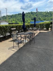 a group of tables and chairs with umbrellas at Comfort Inn Huntington near University area in Huntington