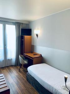 a hotel room with a bed and a desk and a chair at Hôtel Du Lion in Paris