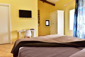 a bedroom with a bed and a tv on the wall at Torre antica suite in Campagnano di Roma