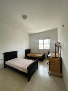 a bedroom with two beds and a dresser in it at Spacious two room apartment with a super view in Bizerte