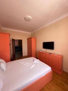 a bedroom with a large bed with a tv on the wall at Apartament Profy in Jurilovca