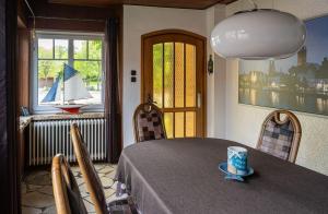 a dining room with a table and a sailboat in a window at Gemütliches Ferienhaus mit großem Balkon in Ahrensbök