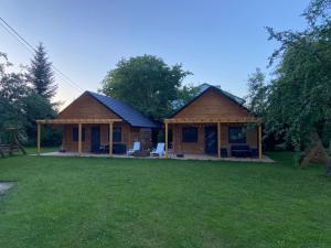 a house with a large yard in front of it at Domki na lipowej in Pastwiska