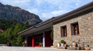 a brick building with mountains in the background at Agathi in Pramanta