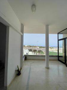 an empty room with a large window in a building at Spacious two room apartment with a super view in Bizerte