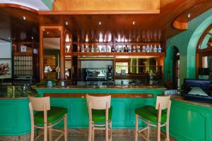 a green bar with three stools in a kitchen at Botanique Hotel Vergani in Fara Gera dʼAdda