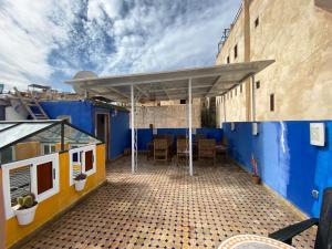 a building with a blue wall and a patio at Dar El Mizan Entier place in Fès