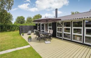 una terraza de madera con mesa y sombrilla en 2 Bedroom Lovely Home In Samsø, en Nordby