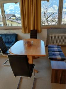 奇勒谷地哈特Ferienwohnung in ruhiger Lage für 5 Personen的有窗户的房间里有一张桌子和几把椅子