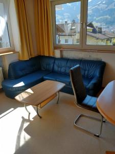 奇勒谷地哈特Ferienwohnung in ruhiger Lage für 5 Personen的客厅里有一张蓝色的沙发和一张桌子