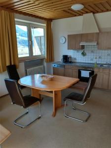 奇勒谷地哈特Ferienwohnung in ruhiger Lage für 5 Personen的厨房配有木桌和四把椅子