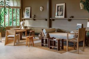 Zimmer mit Sofa, Stühlen und Tischen in der Unterkunft Les Sources de Caudalie in Martillac