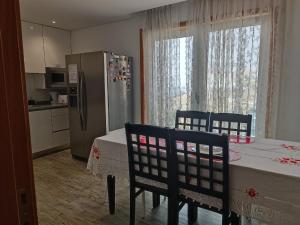 a kitchen with a table and chairs and a refrigerator at Cachinnans Hostel & Apartments in Vila do Conde