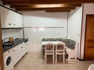 a kitchen with a table and chairs and a sink at Apartamento Cholo I in Brañosera