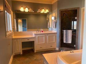 a bathroom with a sink and a mirror and a tub at The Lodge at Stony Point in Jay +78 photos