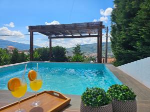 two glasses of wine on a table next to a swimming pool at Vistadouro 3 Style in Peso da Régua