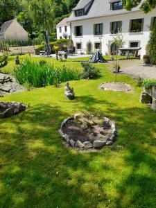 a garden in front of a white house at Gite au Reflet d'Auvers in Auvers-sur-Oise