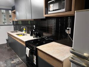 a kitchen with a stove and a microwave at Departamento moderno calle España! in Mendoza