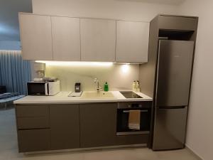 a kitchen with a sink and a refrigerator at Sandy Suite 3 in Agia Marina Nea Kydonias