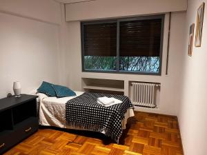 a bedroom with a bed and a tv and two windows at Departamento moderno calle España! in Mendoza