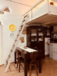 a loft bed in a kitchen with a table and a ladder at Ovostolai Cottage in Fonni +35 photos