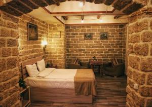 a bedroom with a bed in a brick wall at Antique Hotel Baku in Baku