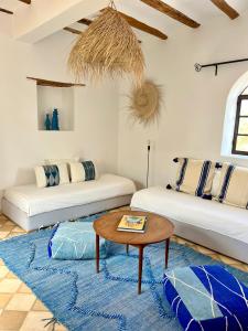 een woonkamer met twee bedden en een tafel bij La Villa Sauvage in Essaouira +25 foto's