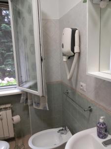 een badkamer met een wastafel en een zeepdispenser aan de muur bij Apartamento vicino Policlinico San Donato in San Donato Milanese