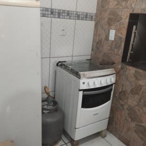 a kitchen with a stove top oven in a room at Perto das cascatas in Santa Maria do Erval
