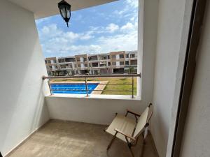 a balcony with a chair and a view of a building at Malaga Beach El Mansouria in Mansouria