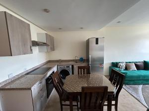 a kitchen with a table and a kitchen with a couch at Malaga Beach El Mansouria in Mansouria