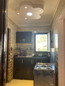 a kitchen with black cabinets and a stove at Chalet of stella Di mere makadi in El Gouna +8 photos
