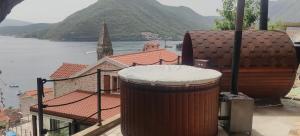 a large trash can on a balcony with a view of the water at Monte Bay Retreat Villa in Perast