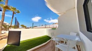einen kleinen Tisch und Stühle auf einem Balkon mit Gras in der Unterkunft DUNASOL Home, by Comfortable Luxury in Corralejo