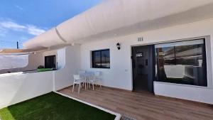 Dieses weiße Haus verfügt über einen Balkon mit einem Tisch und Stühlen. in der Unterkunft DUNASOL Home, by Comfortable Luxury in Corralejo + 40 Fotos