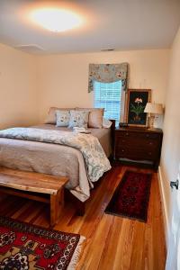 a bedroom with a bed and a table and a window at James Armistead Lafayette Cottage in Cumberland Landing