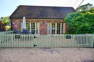 a white fence in front of a small house at James Armistead Lafayette Cottage in Cumberland Landing