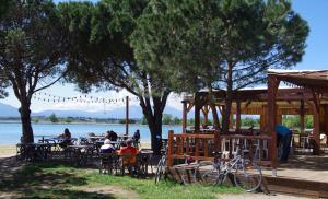 a group of people sitting at tables by the water at Brit Hotel Porte d'Espagne in Perpignan