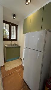 a kitchen with a white refrigerator and a sink at ZenSo Studios in Tolo +48 photos