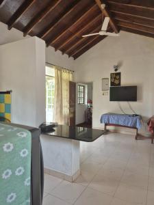 a living room with a table and a tv at SkyView Villa in Candolim