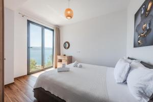 a bedroom with a bed and a large window at Casa Mare in Vlorë
