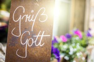 a sign that reads our cut sitting in front of flowers at Hotel Maximilian in Reutte