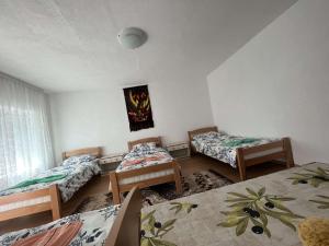 una habitación con tres camas y una ventana en Guest House GURI, en Vusanje