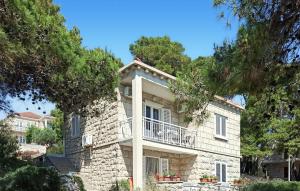 a large stone house with a balcony and trees at Apartment Lumbarda Iv in Lumbarda +32 photos