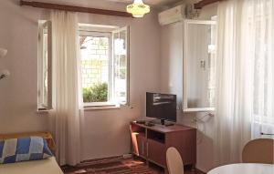 a bedroom with a tv on a dresser with a window at Apartment Lumbarda Iv in Lumbarda