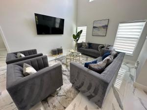 a living room with two couches and a flat screen tv at Beautifully Remodeled Home - Southen Dunes Golf Course Views in Haines City