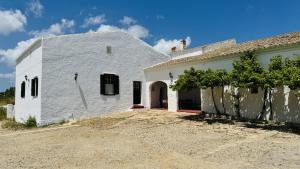 ein weißes Haus mit einer Auffahrt neben einem Gebäude in der Unterkunft Holiday Home Finca Binimazoch in Port d'Addaia